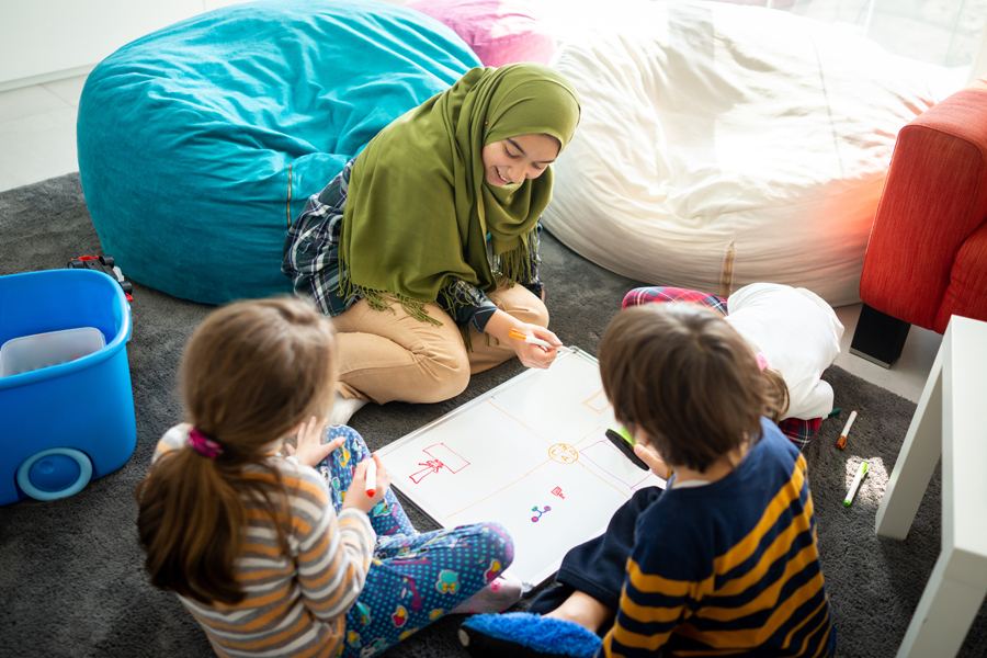 A volunteer working through a lesson with two children
